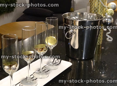 Stock image of row of four wine-glasses on tray, wine bucket