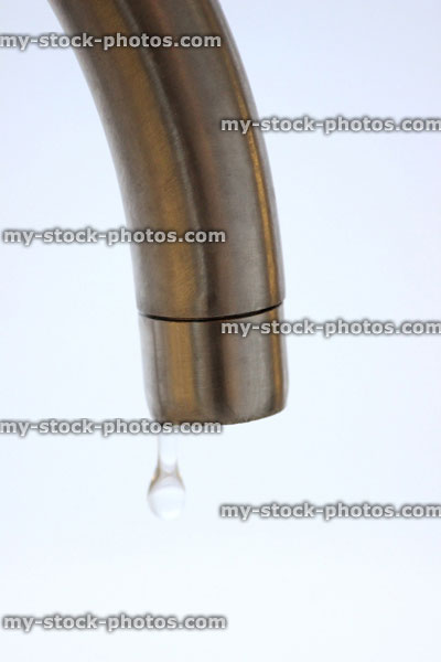 Stock image of dripping tap with water droplet, contemporary chrome tap