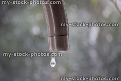 Stock image of dripping tap with water droplet, contemporary chrome tap
