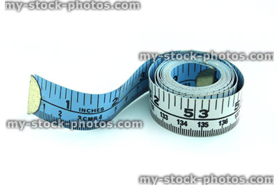 Stock image of tape measure coiled up, starting to unravel