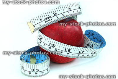 Stock image of tape measure with ripe red apple, fresh fruit