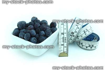 Stock image of tape measure with fresh organic blueberries in dish