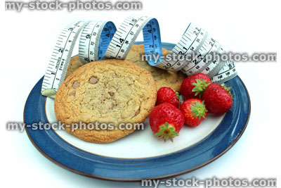 Stock image of tape measure with chocolate chip cookies and strawberries
