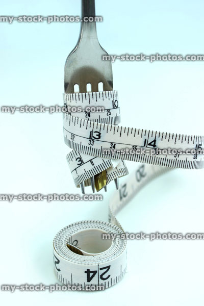 Stock image of tape measure wrapped around silver fork like spaghetti