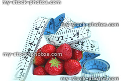 Stock image of tape measure with fresh organic strawberries in dish