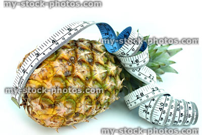 Stock image of tape measure with pineapple, fresh organic pineapple