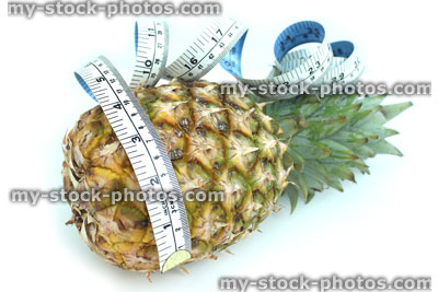 Stock image of tape measure with pineapple, fresh organic pineapple