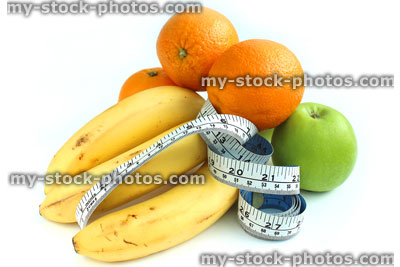 Stock image of tape measure with fresh fruit, apples, bananas, oranges
