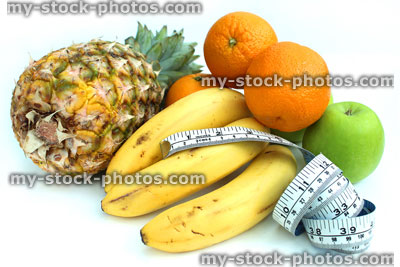 Stock image of tape measure with fruit, apples, bananas, oranges, pineapple