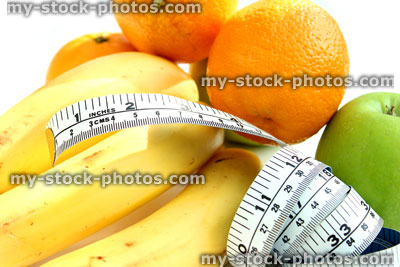 Stock image of tape measure with apples, bananas, oranges, fresh fruit