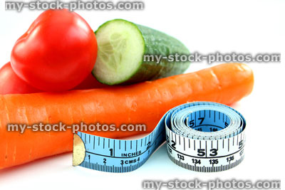 Stock image of tape measure with tomatoes, carrot, cucumber, fresh vegetables