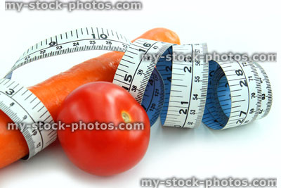 Stock image of tape measure with carrot and tomato, fresh vegetables