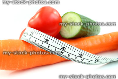 Stock image of tape measure with tomatoes, carrot, cucumber, fresh vegetables