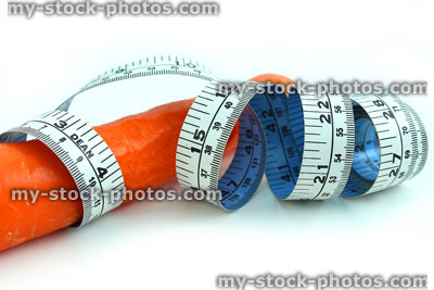 Stock image of tape measure with carrot, fresh organic carrot vegetable