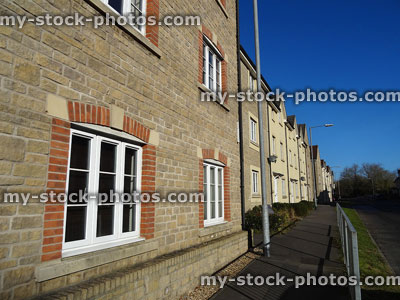 Stock image of brick and rendered new-build terraced houses, road, pavement
