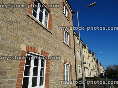 Stock image of new-build brick terraced houses looking historic, street lamp