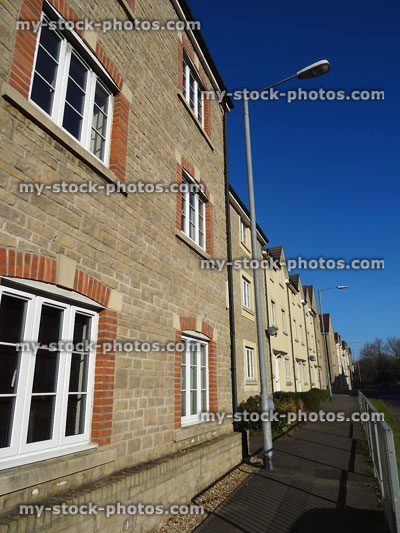 Stock image of new-built brick terraced houses row and tarmac pavement