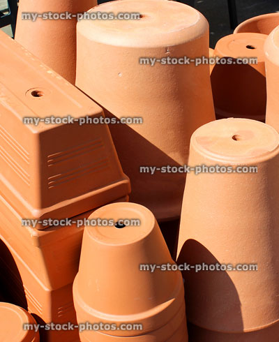 Stock image of stacks of large terracotta garden pots and troughs
