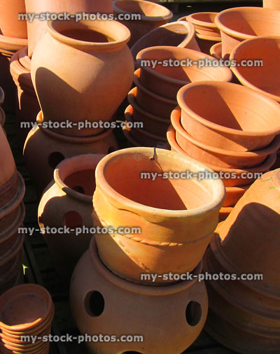 Stock image of stacks of large terracotta garden pots, troughs, strawberry pots