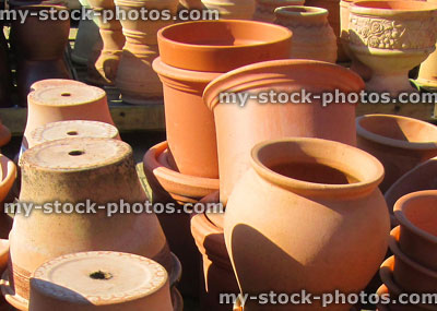 Stock image of stacks of large terracotta garden pots and troughs