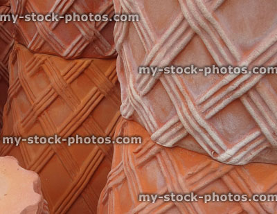 Stock image of stacks of large hand thrown, decorated terracotta garden pots and troughs