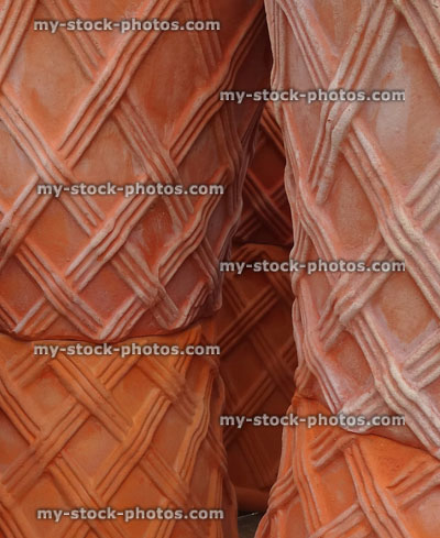 Stock image of stacks of large hand thrown, decorated terracotta garden pots and troughs