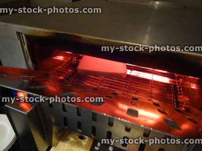 Stock image of stainless steel commercial conveyor toaster / grill, pictured toasting bread