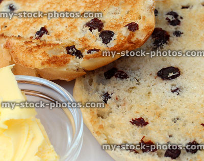 Stock image of toasted teacakes on white plate, with butter on side