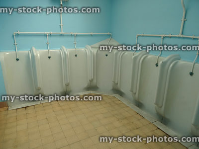 Stock image of white ceramic urinals for men, gents public toilets