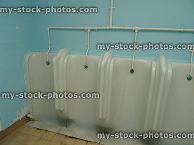 Stock image of white urinals row, in men's public toilets / gents