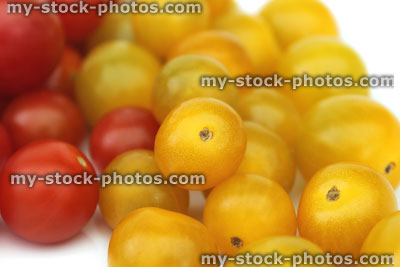 Stock image of small yellow and red cherry tomatoes in piles