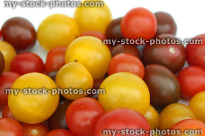 Stock image of mixed yellow, red, green and purple cherry tomatoes