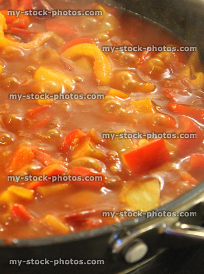 Stock image of tomato ratatouille with onions and red bell peppers, cooking, simmering