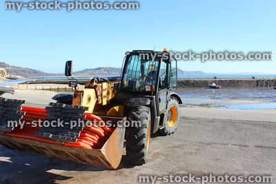 Stock image of tractor parked by seaside harbour / beach
