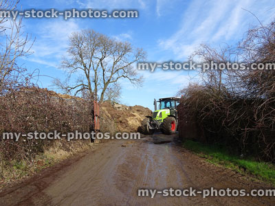 Stock image of muck spraying tractor leaving farm, by manure pile