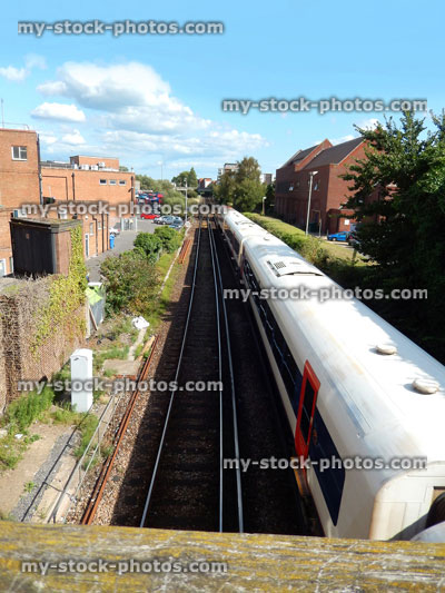 Stock image of railway line / railroad tracks heading through town, train passing houses