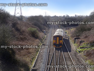 Stock image of railway line / railroad tracks, junction box, diesel train, electricity pylon