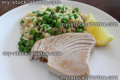 Stock image of healthy lunch, tuna fish / tuna steak, brown rice, peas, lemon