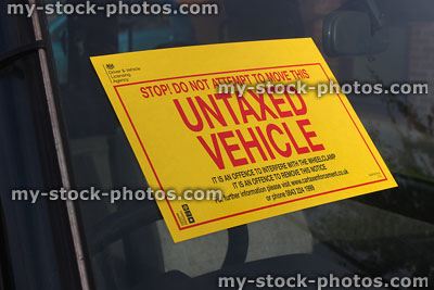 Stock image of yellow sign on car window / windscreen, untaxed vehicle