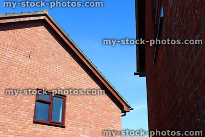 Stock image of brown UPVC bathroom window with frosted glass, red brick house