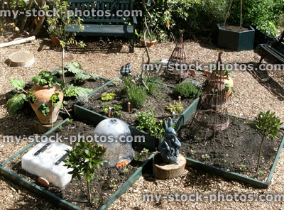 Stock image of vegetable garden with raised bed, bay trees, herbs
