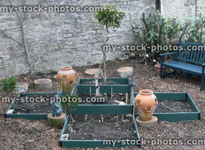 Stock image of raised bed in vegetable garden, terracotta strawberry pots