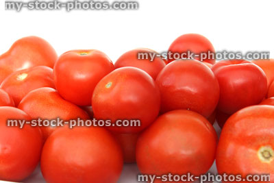 Stock image of fresh, red salad tomatoes in pile, health benefits, white background
