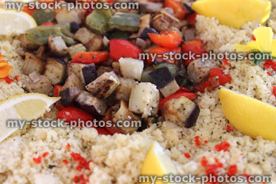 Stock image of vegetarian couscous salad with fried mushrooms, red peppers, lemon slices