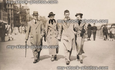 Stock image of 1930s family walking on Weymouth promenade, vintage / retro black and white photograph