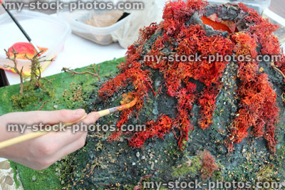 Stock image of girl painting model volcano, made for school project