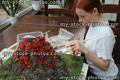 Stock image of girl painting model volcano, made for school project