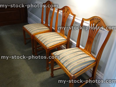 Stock image of row of antique wooden chairs, private hospital waiting room