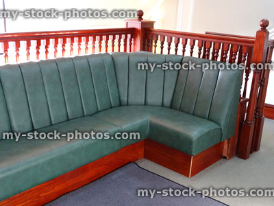 Stock image of private hospital waiting room seating, green wooden corner sofa