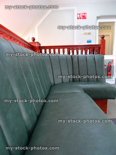 Stock image of private hospital waiting room corner seating, green leather sofa / bonket seat